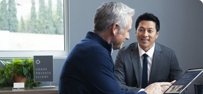 A Chase Private Client Savings customer going over documents on a tablet with their banker