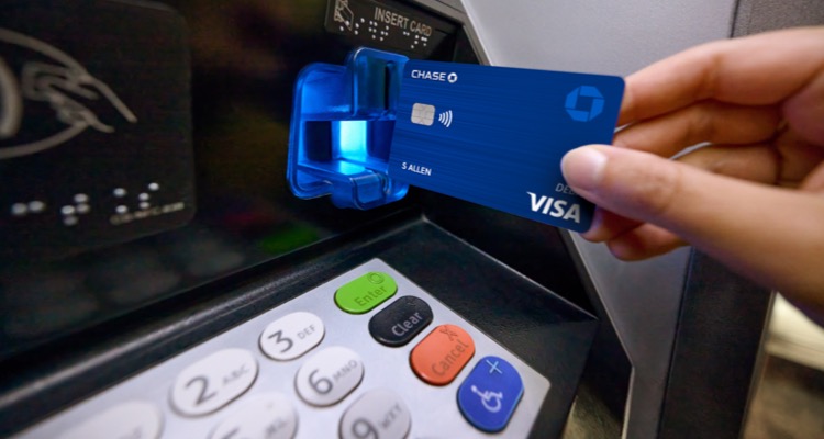 Una mano inserta una tarjeta de débito en un cajero automático de Chase para retirar dinero